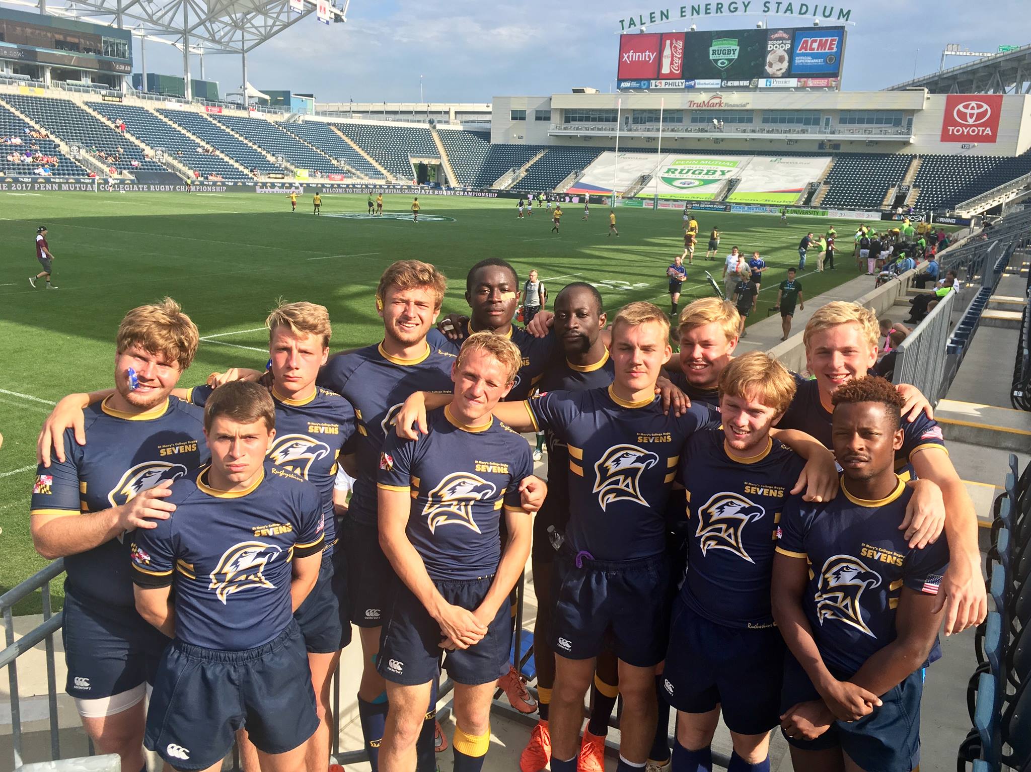 St. Mary's College men's rugby team poses for a picture in a large football stadium.