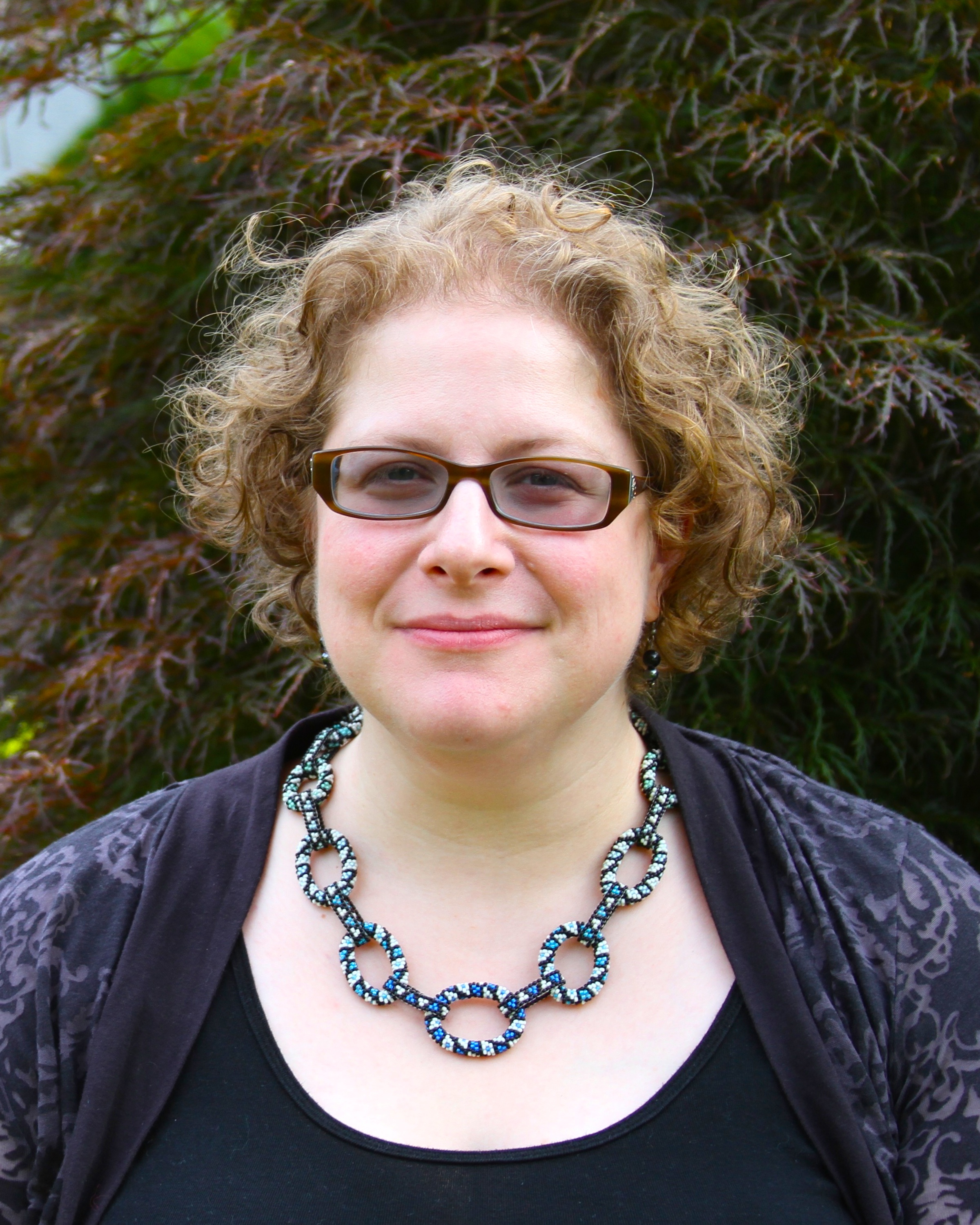 Susan Goldstine in front of foliage