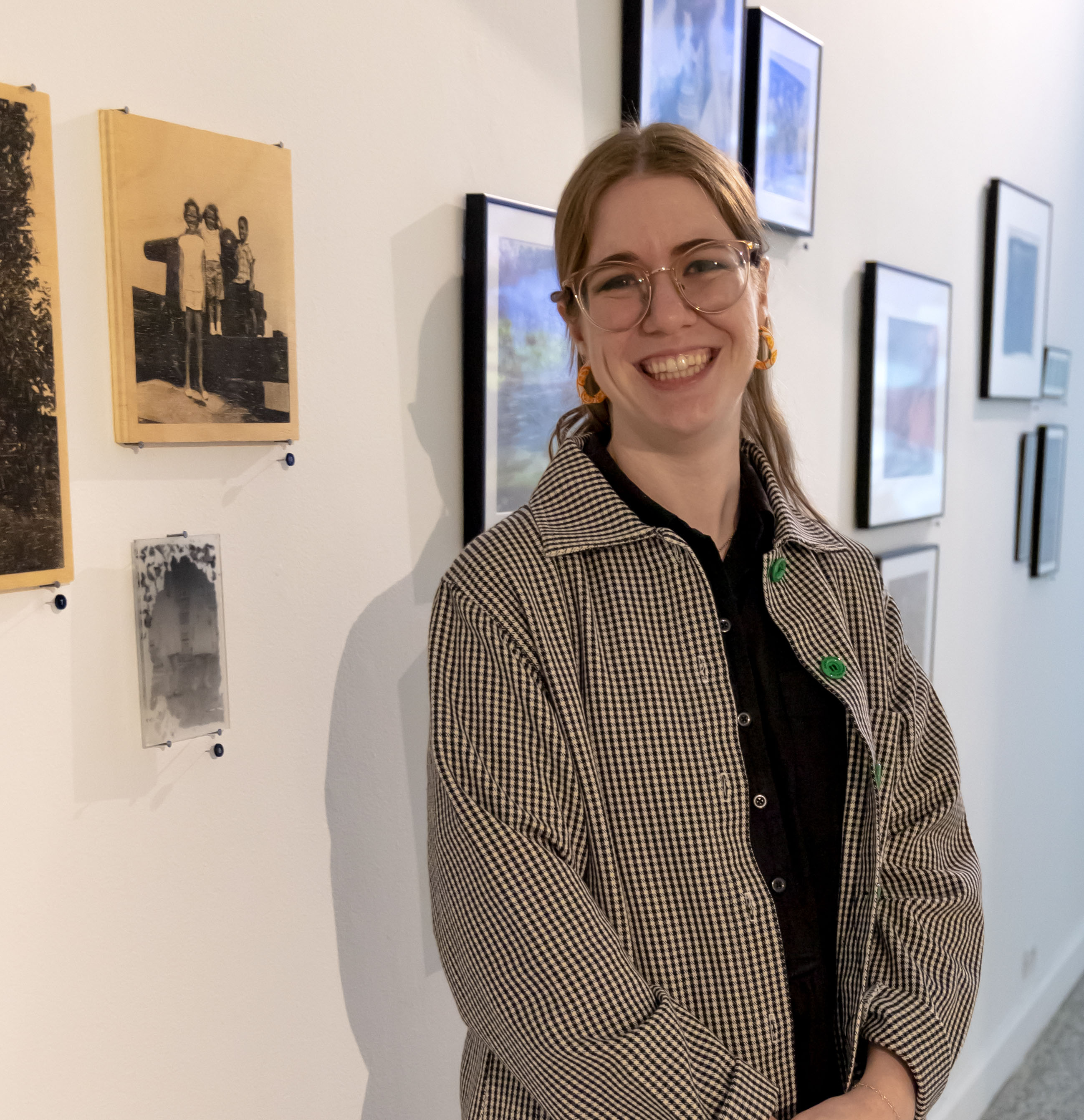 Photograph of Elizabeth Kelly standing in front of her artwork in a gallery