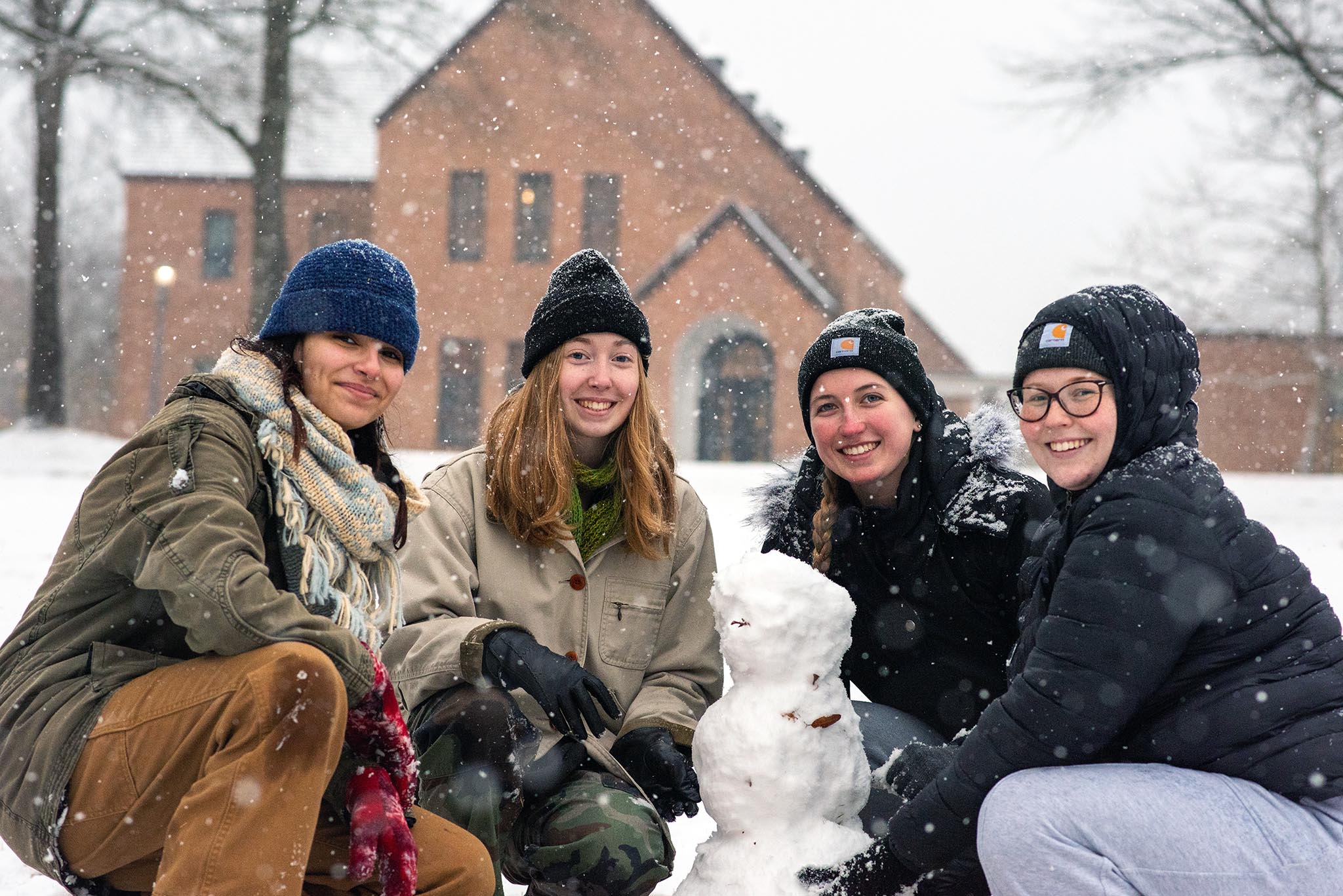 4 students building a snowman