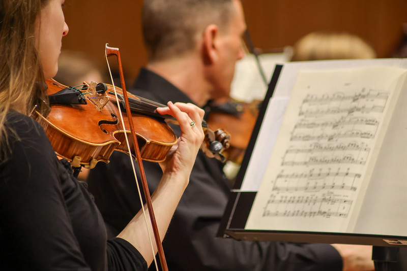 Close up of Violinists looking at sheet music, playing violin 