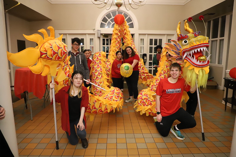 Students hold up decorative dragon In DPC 