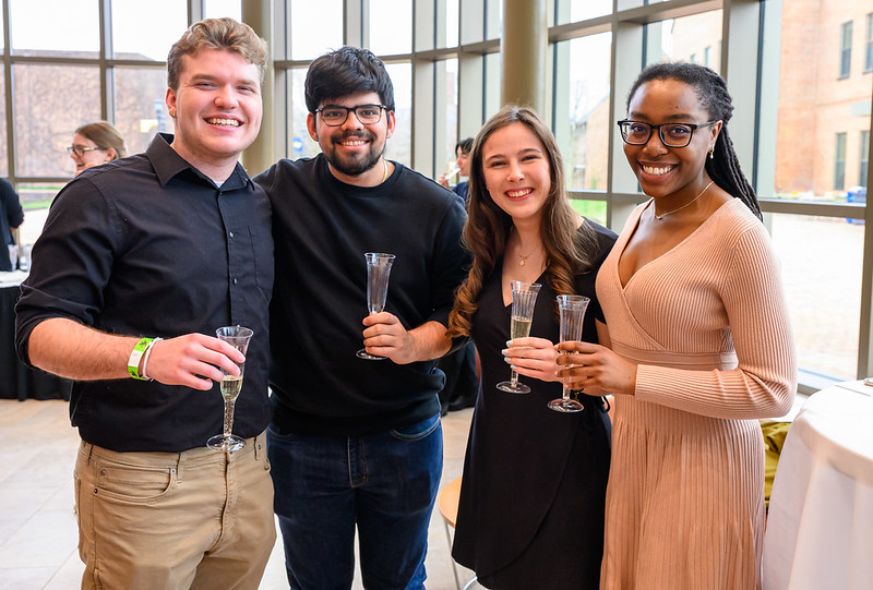 4 students holding champagne glasses