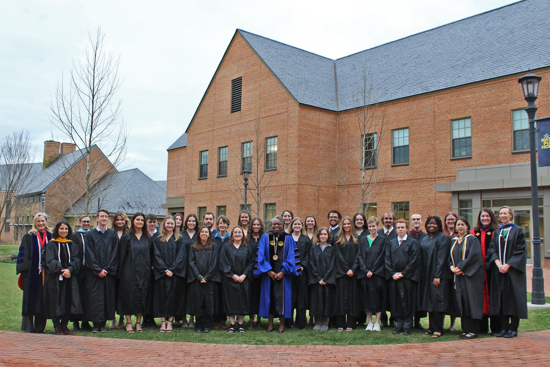 Group of students in faculty standing outside in academic robes