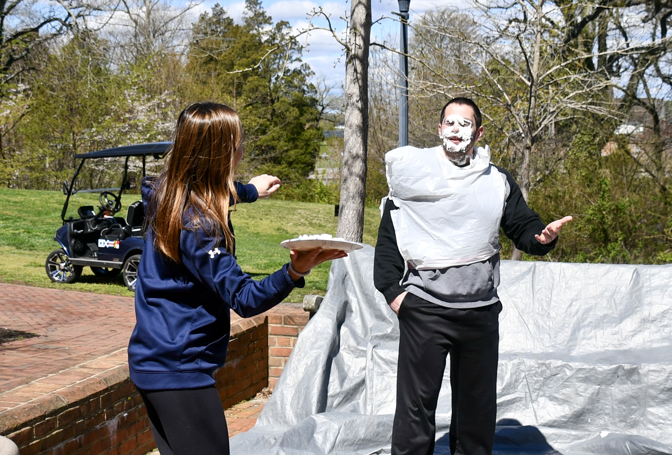 An athlete pies a coach at the campus center patio 