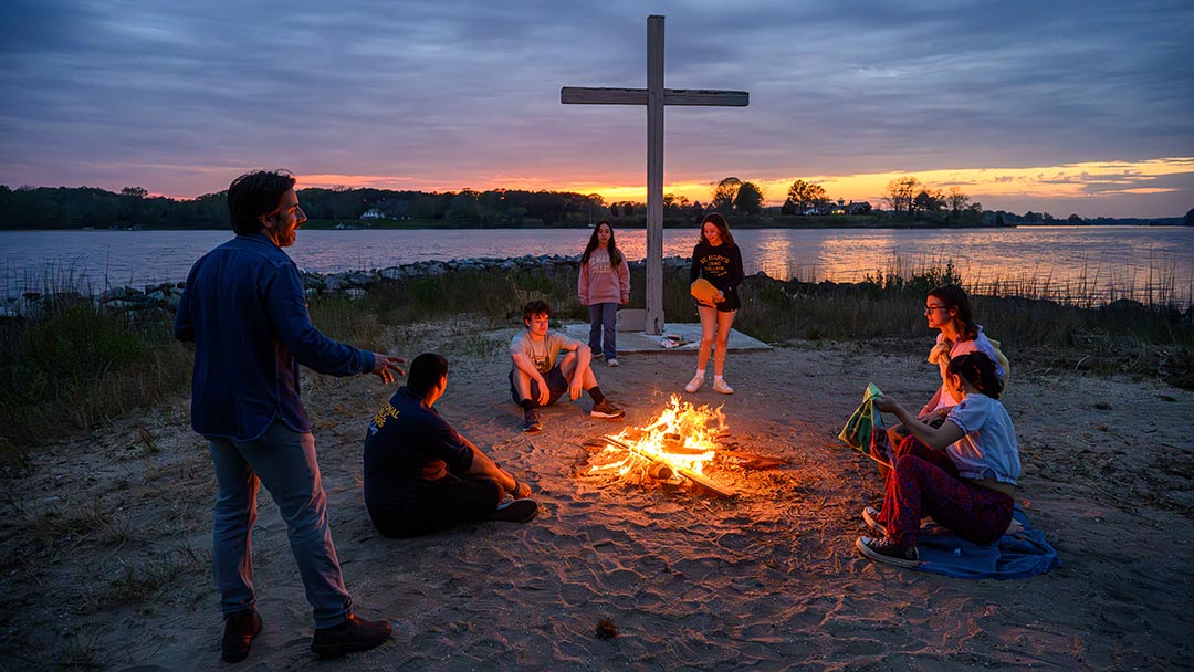 Photographer with students gathered around fire