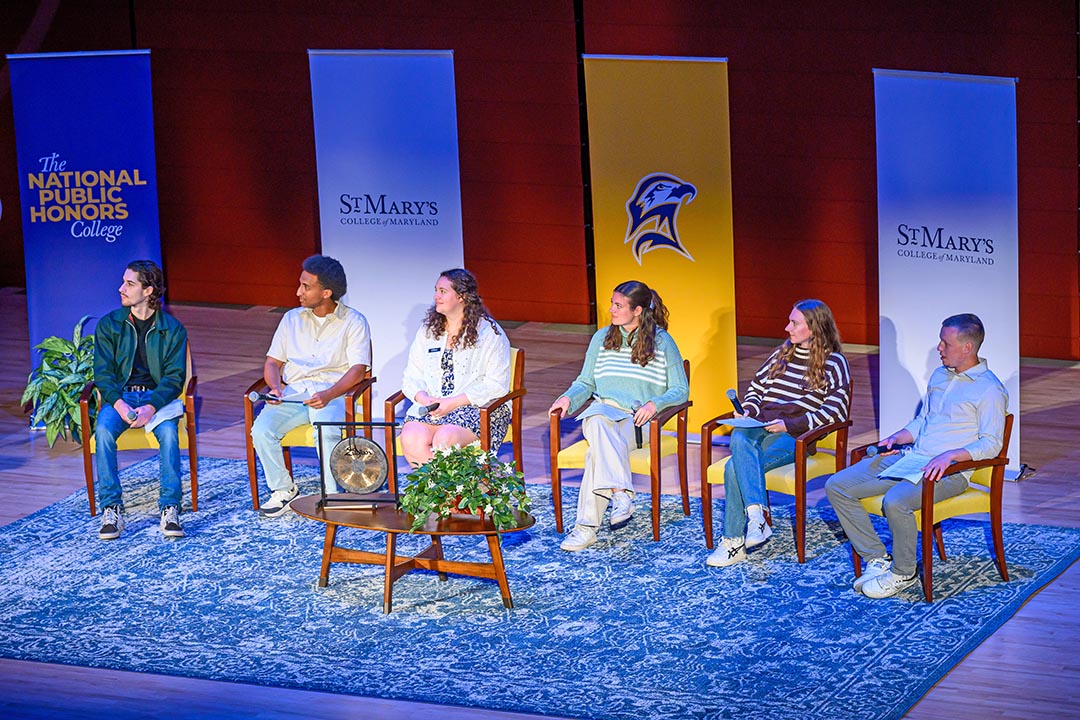 Six students seated on stage