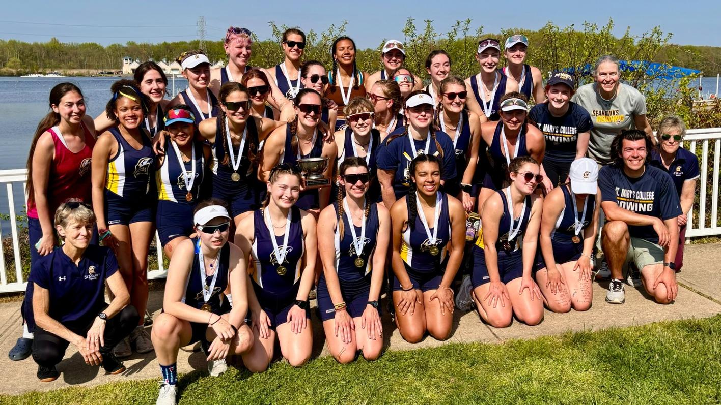 Photo of women rowers & coaches wearing championship medals