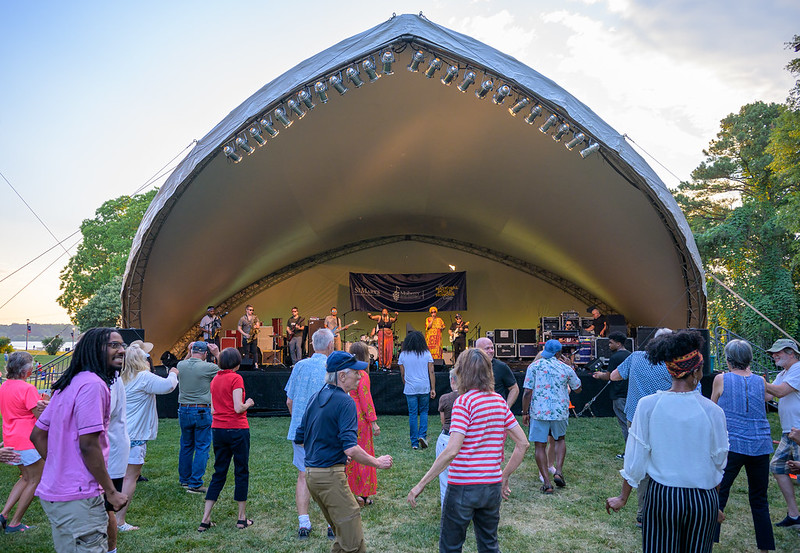 People dancing in front of band on outdoor stage