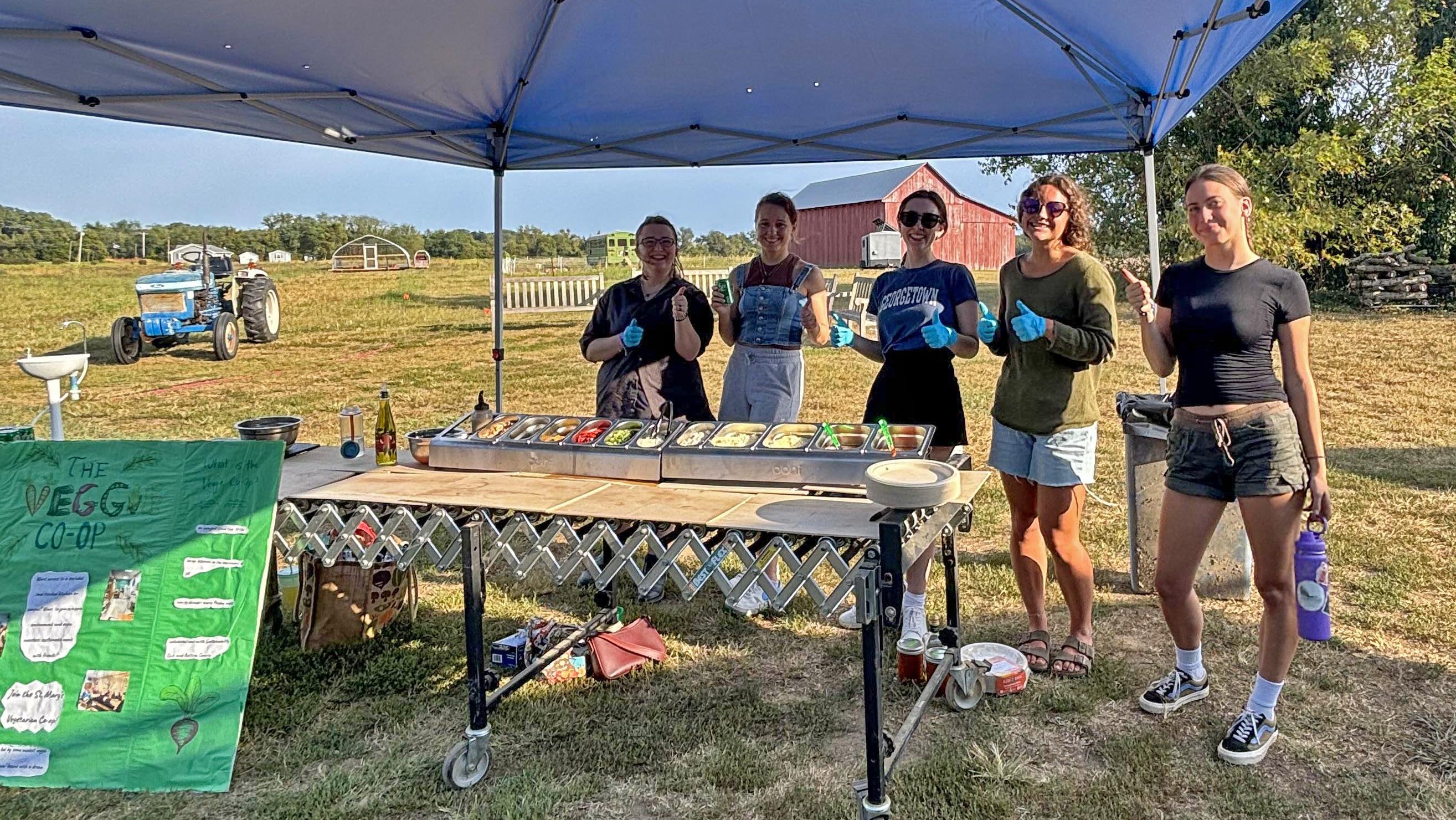 Members of the Veggie Co-op and Farm Club serve up fresh pizza on a beautiful night at Kate Farm.