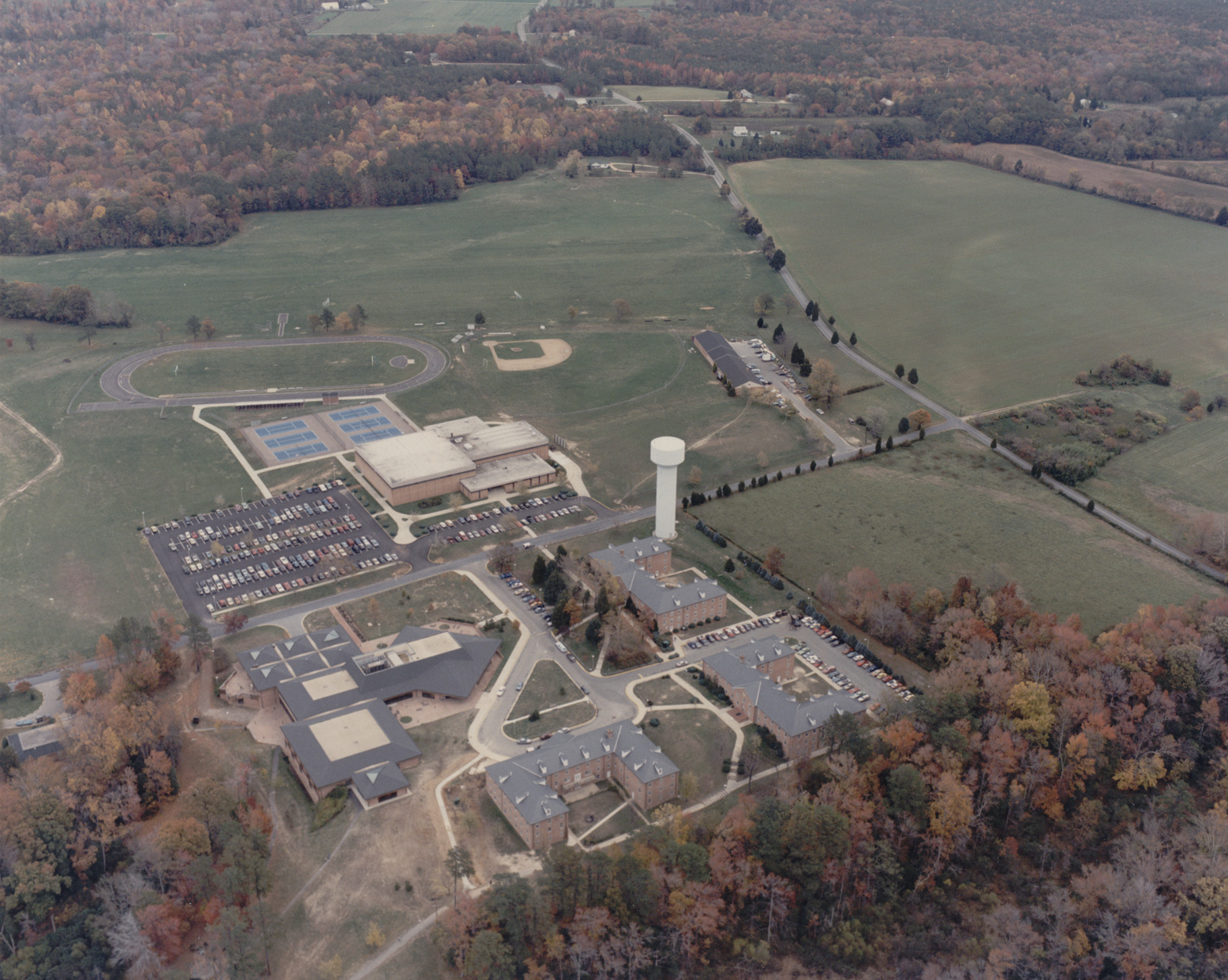 fall campus 1986 showing water tower, gym, tennis courts, track