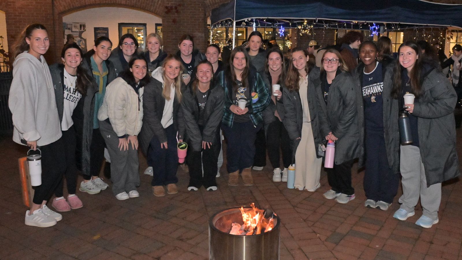 group of women at Giving Tuesday tent around fire pit