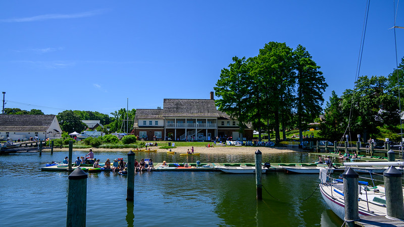 View of the River Center with sun bathers and kayakers in the foreground