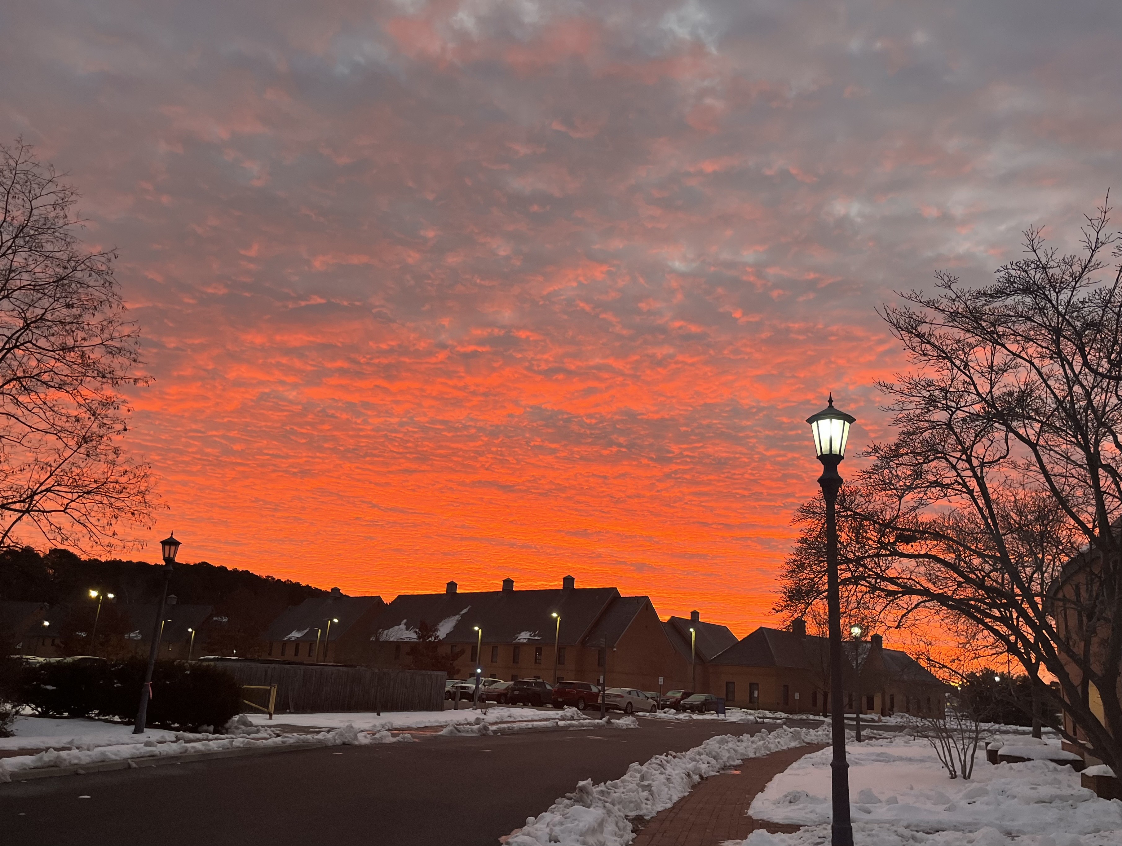 A vibrant red sky filled with fluffy clouds, creating a dramatic and striking atmosphere at sunrise.