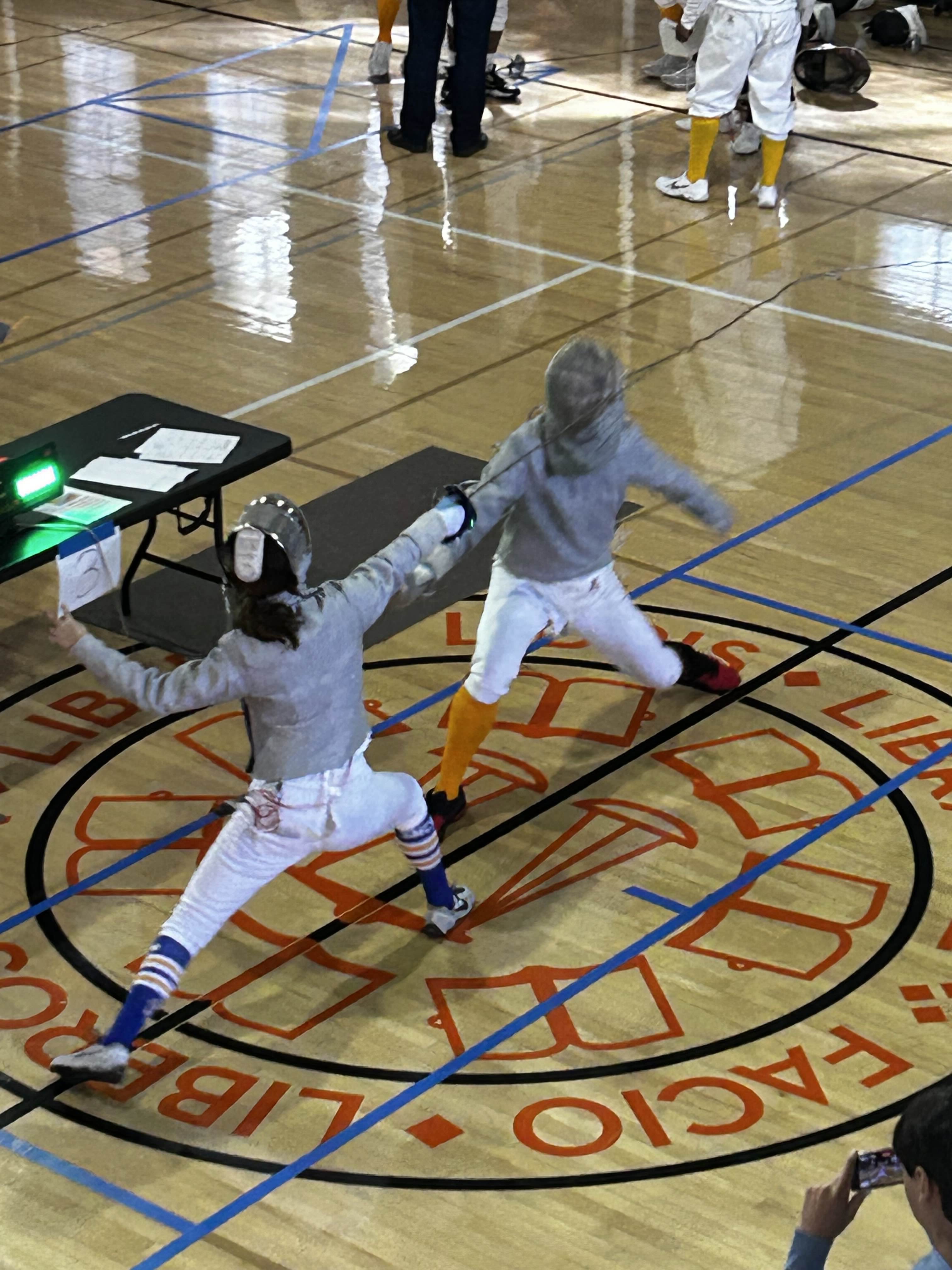 Two people engaging in a fencing duel