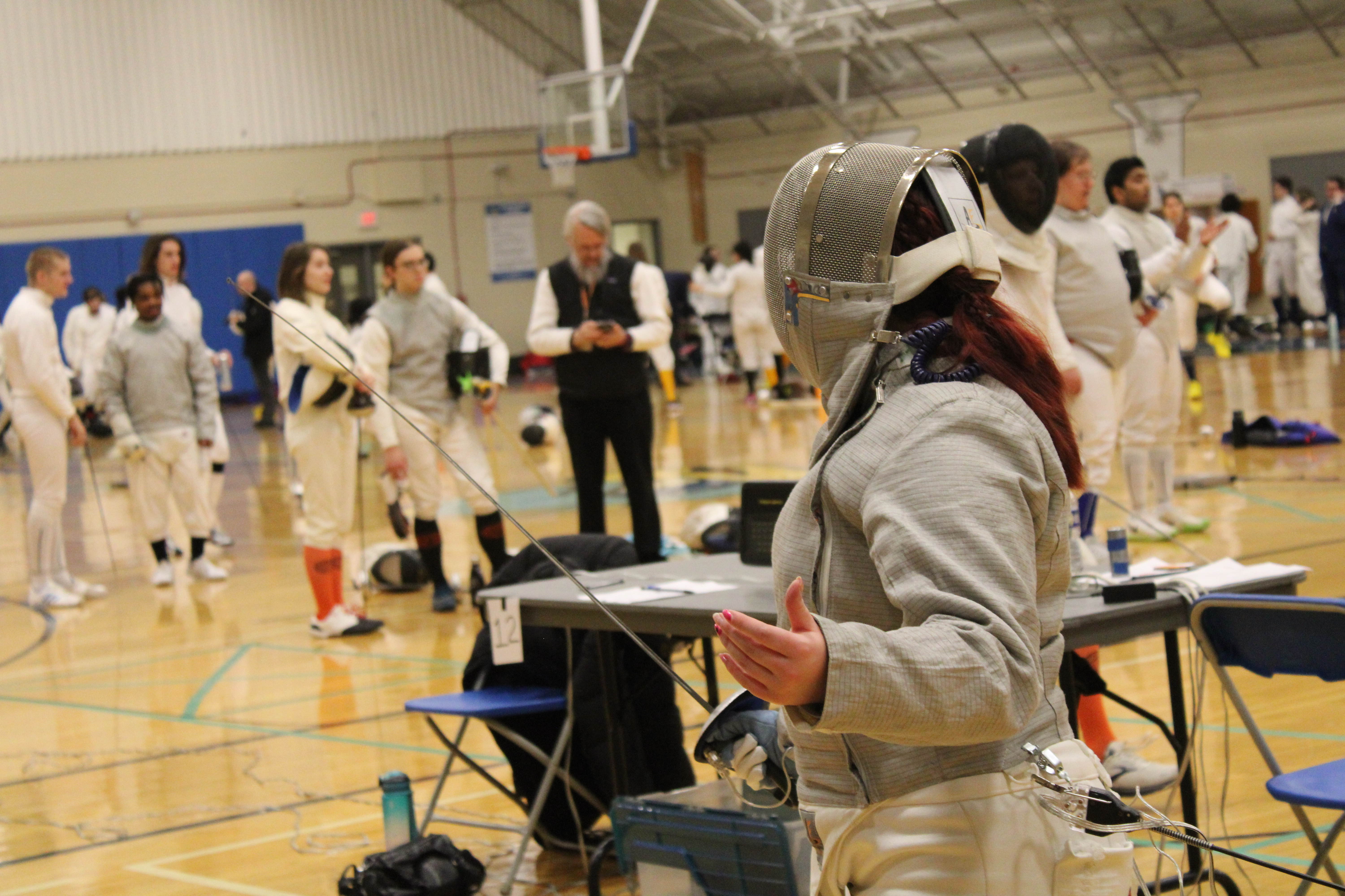 The back of a fencer posing with their sword