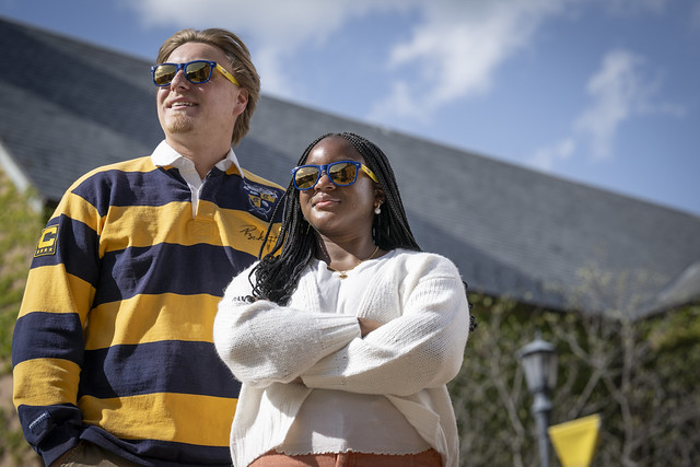 Two SMCM students in sunglasses standing outside on a sunny day