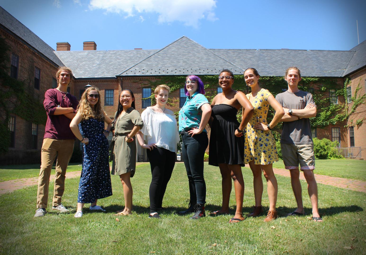 students posing in front of academic building pictured