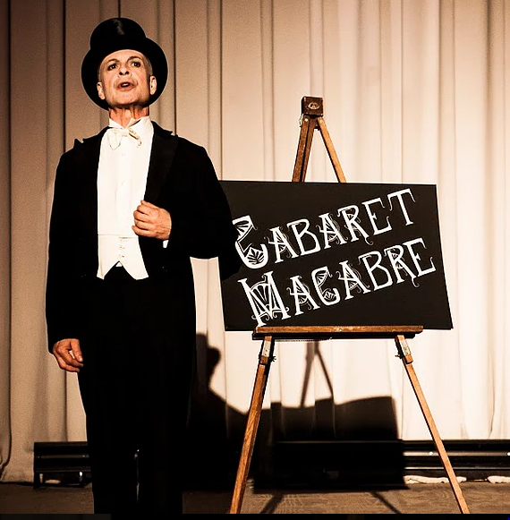 Cabaret Macabre image of conductor in front of sign board with name of the play