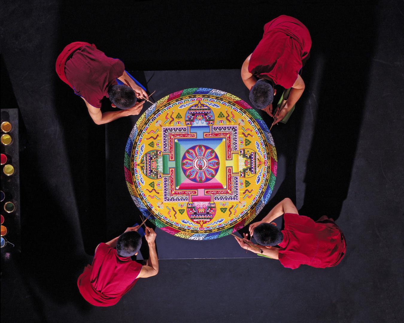 Tibetan Buddhist Monks constructing a Mandala Sand Painting shown