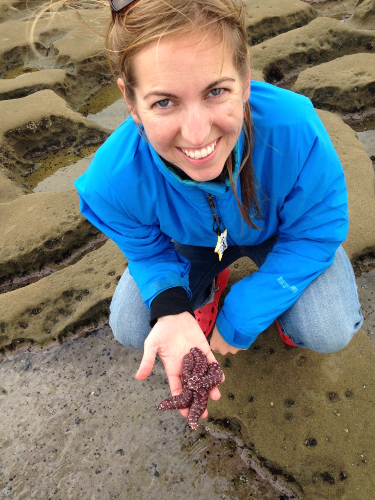 Cassie Gurbisz pictured holding a starfish on a beach