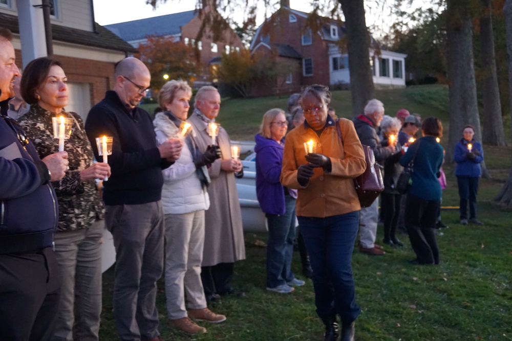 The lives of those enslaved were honored with a reading of their names, candle lighting, celebration, libation, remembrance and reflection at the Waterfront Ceremony. Dr Jordan and guests pictured holding candles. 