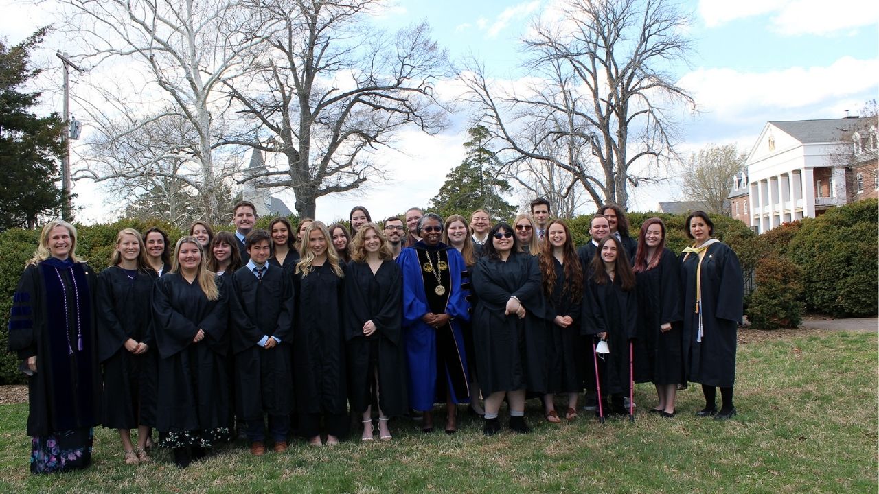 Phi Beta Kappa's Zeta Chapter of Maryland inductees pose for an image outside with Calvert Hall in background 