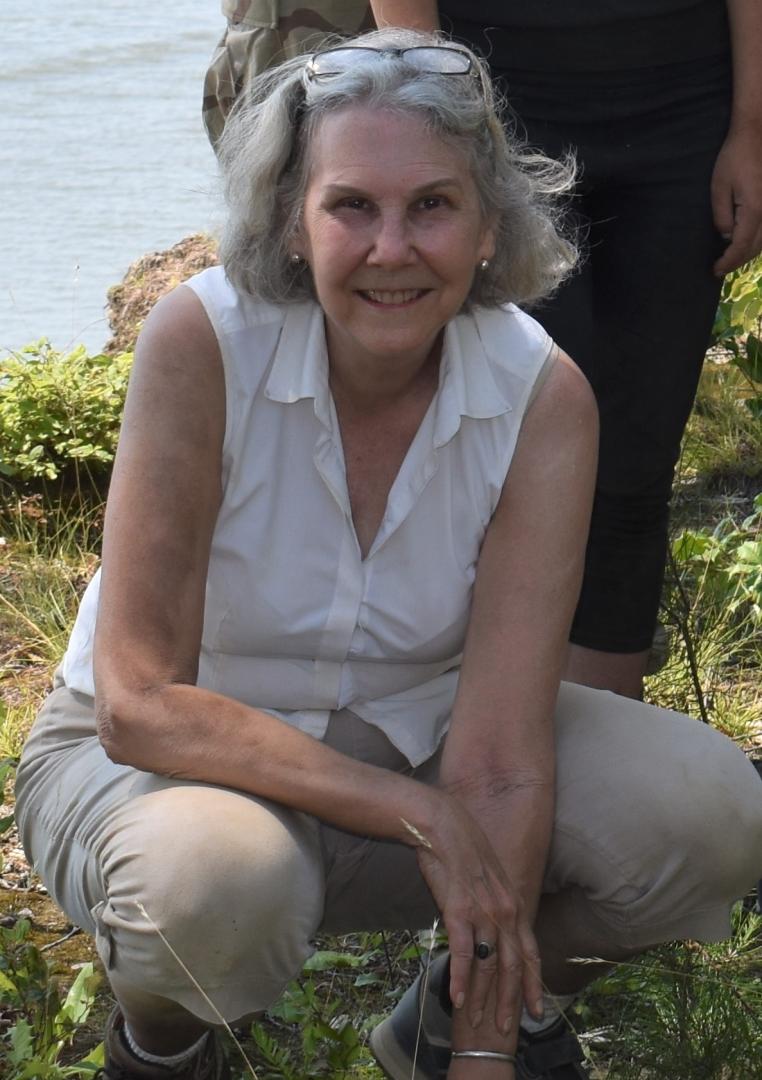 Julia King looks up from an archaeological site