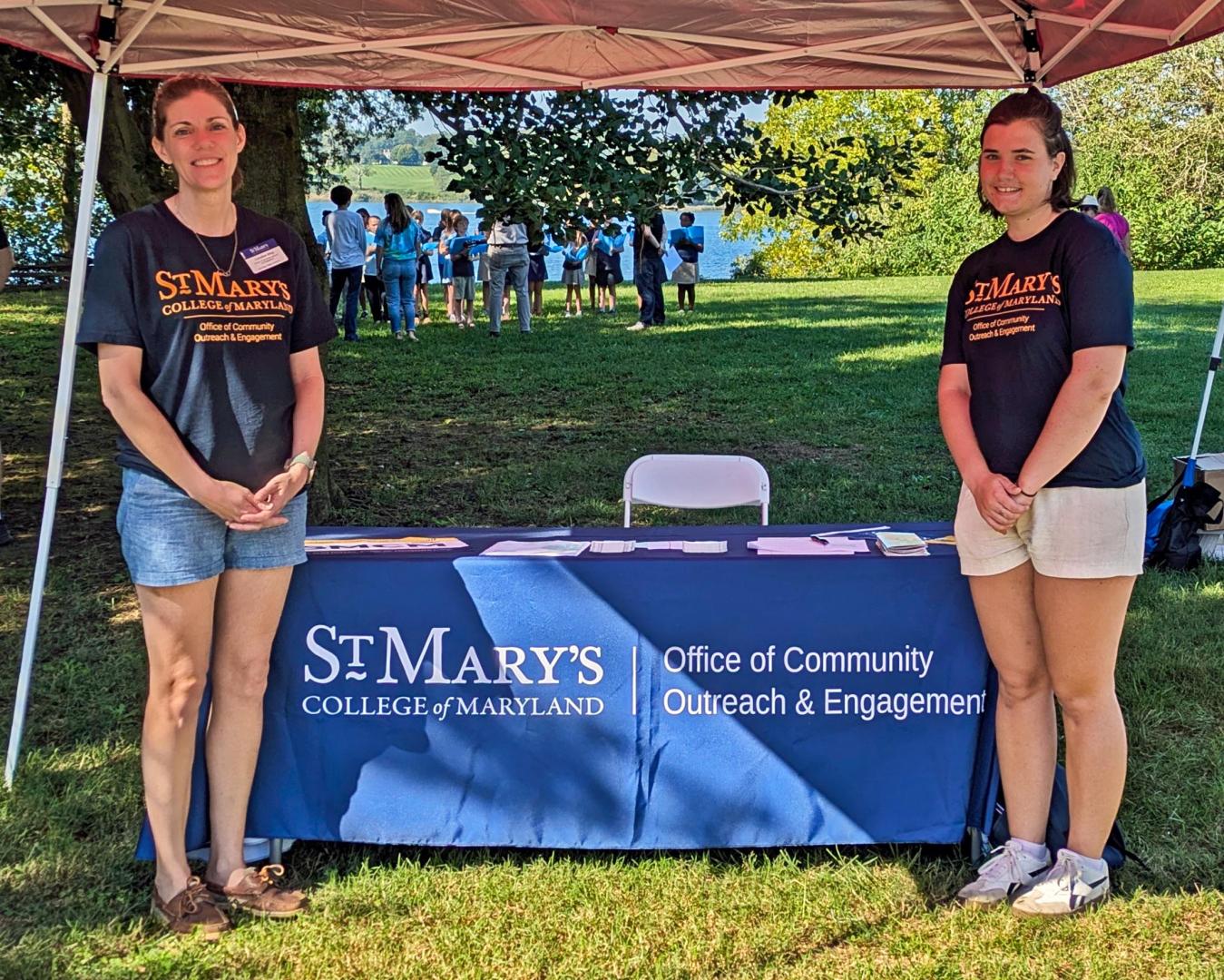 Two women presenting info at an outdoor event