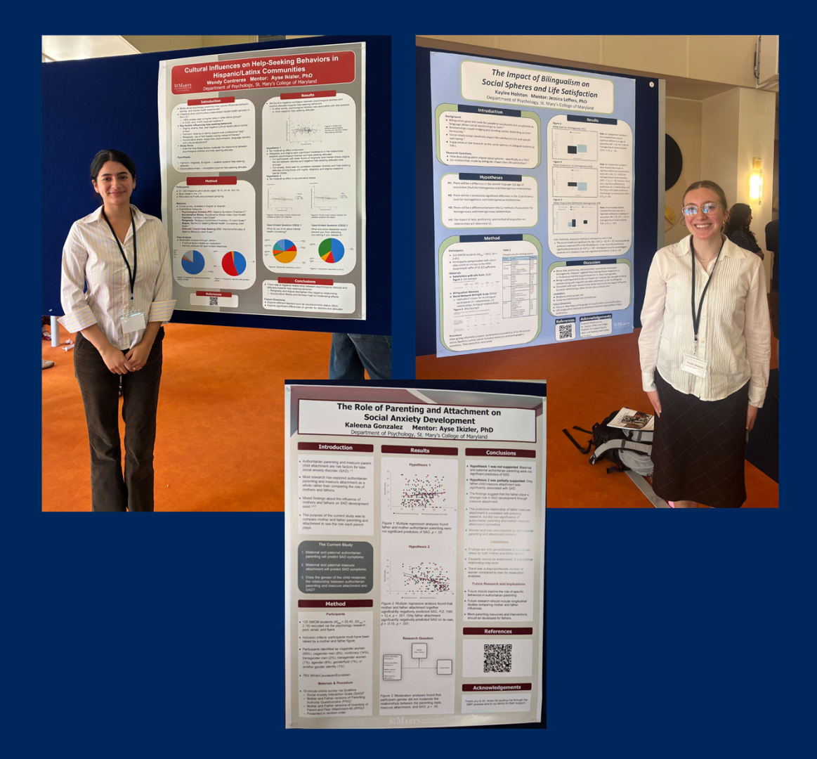 Three academic posters about social behavior research are displayed on boards; two individuals stand beside their respective posters, each wearing conference badges.