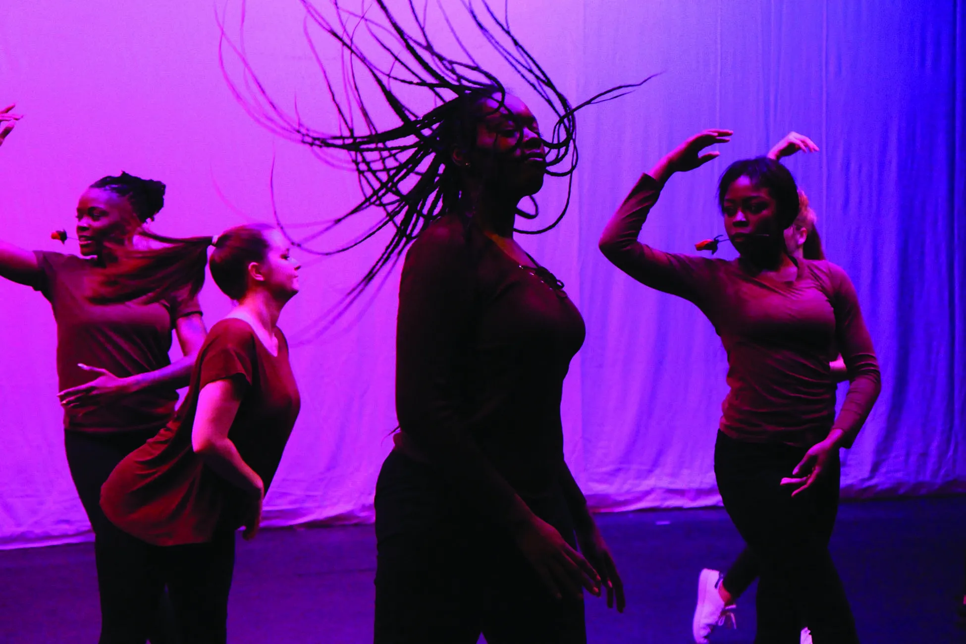 Five students dancing on stage