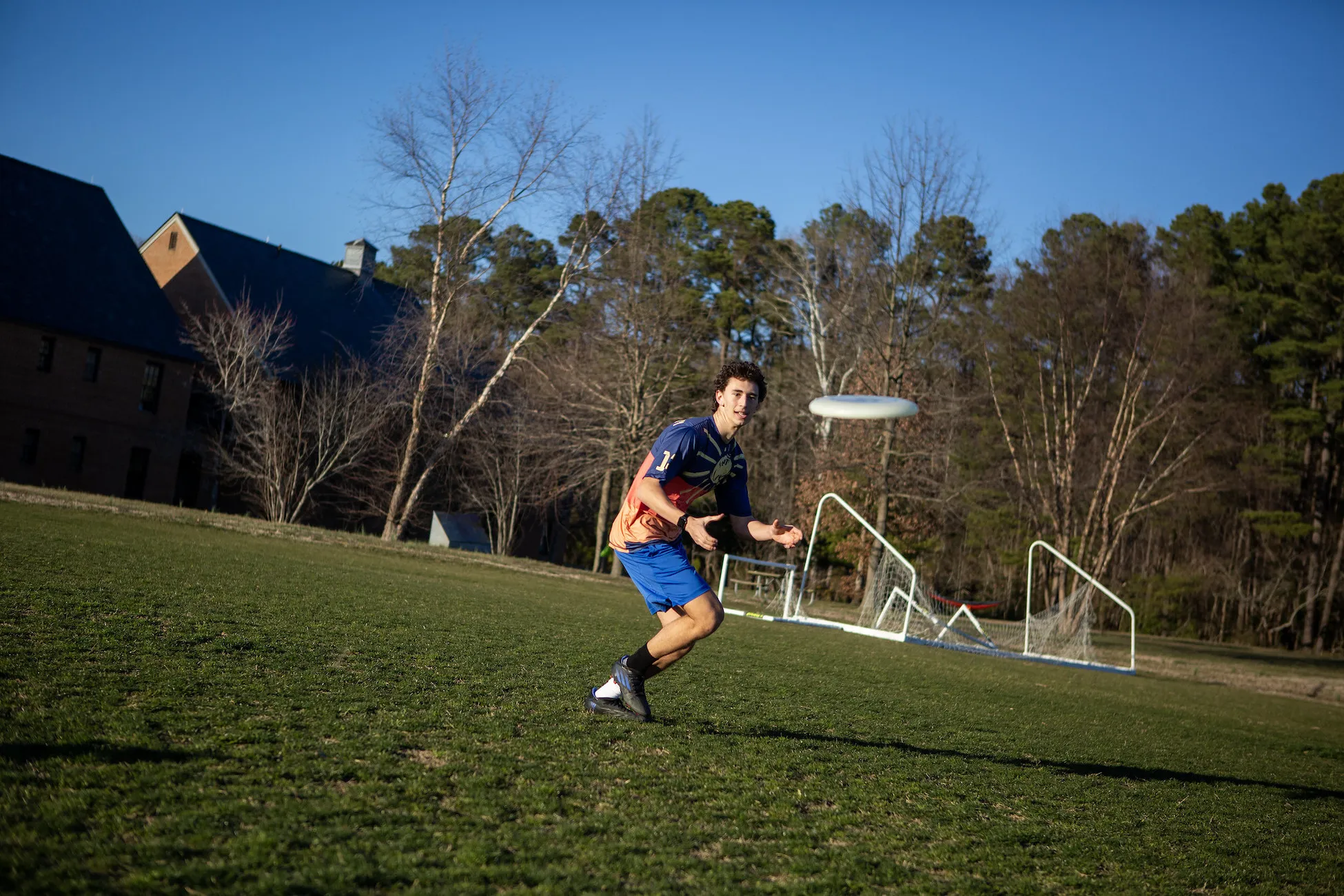 A student in a field throwing a frisbee