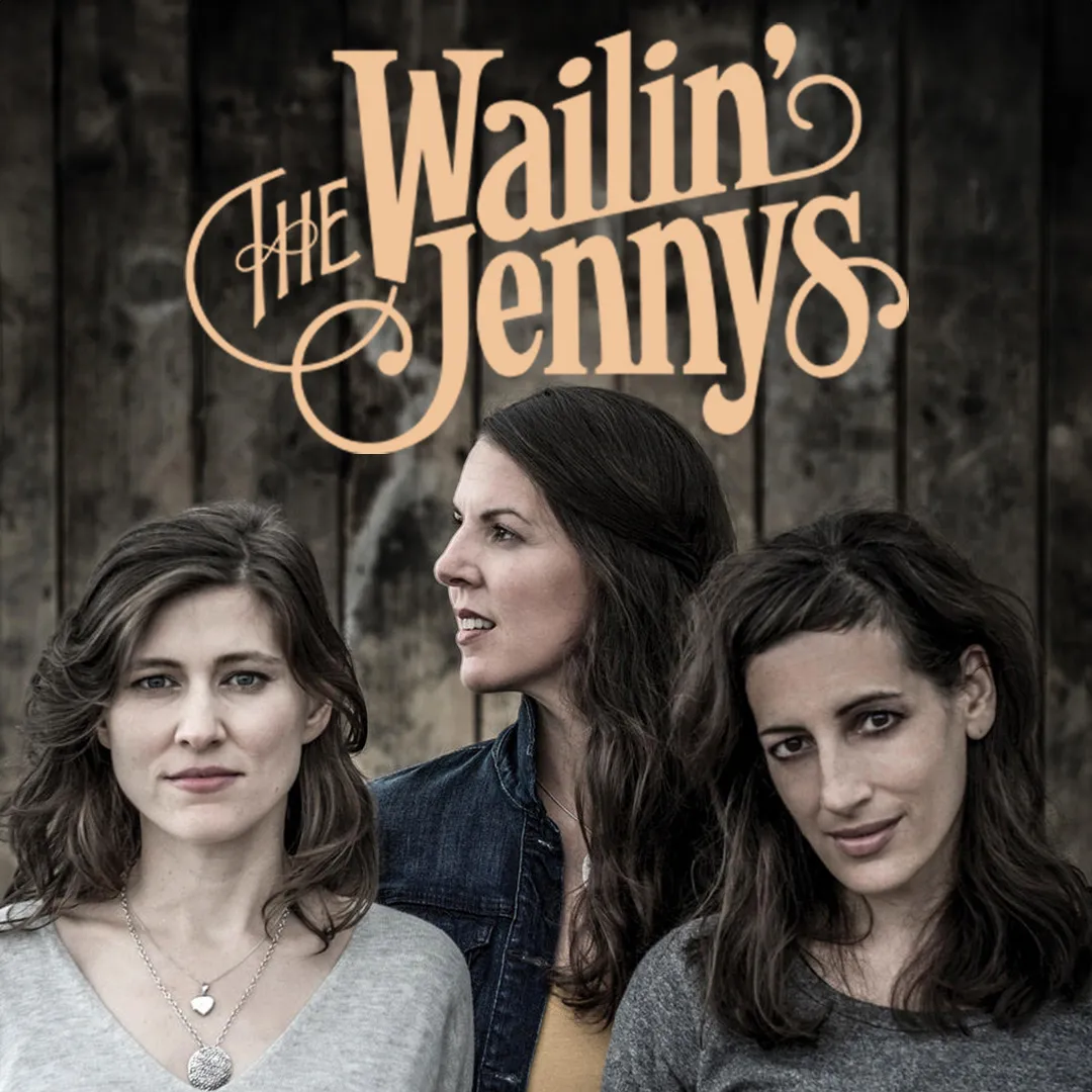 The Wailin' Jennys band logo over three women's portraits against a wood background.