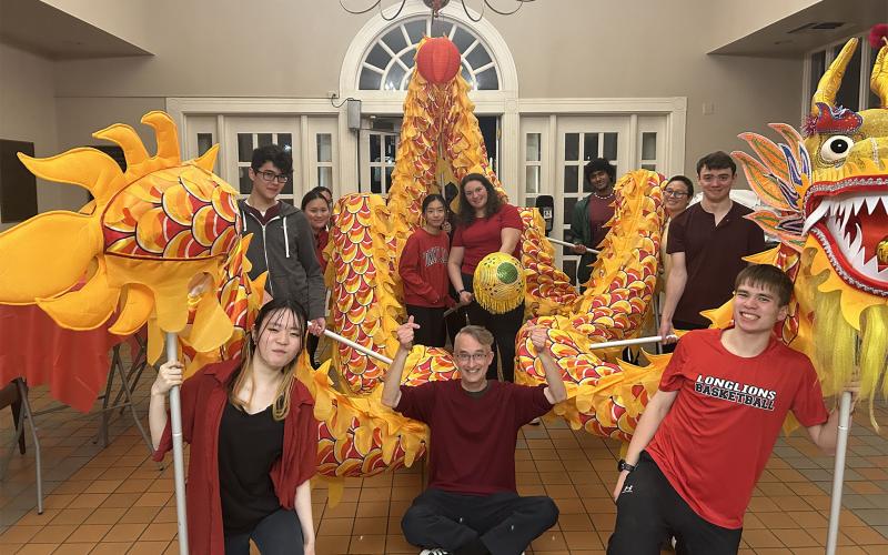 Several students posing with a Dragon