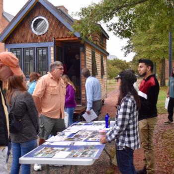 Students welcoming prospective students and parents at the Tiny House displace