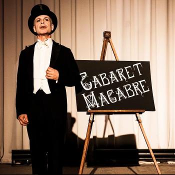 Cabaret Macabre image of conductor in front of sign board with name of the play