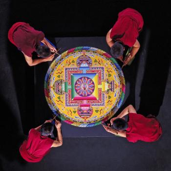Tibetan Buddhist Monks constructing a Mandala Sand Painting shown