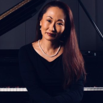 Rie Moore pictured sitting at a piano