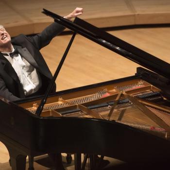 Pianist Brian Ganz sitting at a piano on stage 