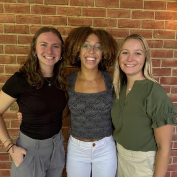 An image of Shelby Ditman, Britney Douglas and Sara Dapp outside infant of a brick wall 