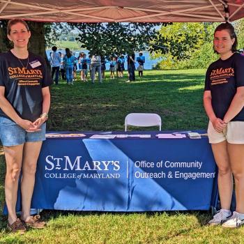 Two women presenting info at an outdoor event