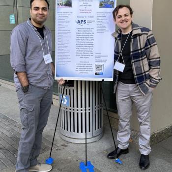 Anish Agashe (left) and Alex Stornelli (right) stand on either side of a conference poster displayed on a stand outdoors, both smiling at the camera.