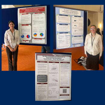 Three academic posters about social behavior research are displayed on boards; two individuals stand beside their respective posters, each wearing conference badges.