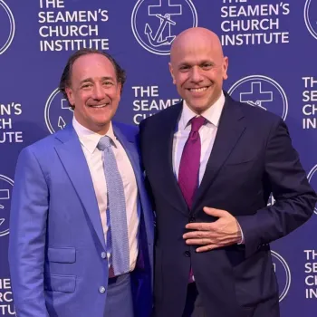 Two men in suits pose and smile in front of a step-and-repeat backdrop with "The Seamen's Church Institute" logo and text.