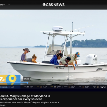 Four people are on a small white boat on a calm body of water under a cloudy sky. The boat has a canopy and is labeled “MD 8091 BE.” The CBS News logo is visible at the top of the image.