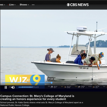 Four people examine something on a small white boat on the water during a CBS News segment about St. Mary’s College of Maryland.