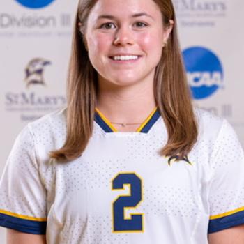 A female college soccer player wearing a white jersey with the number 2 on the front.