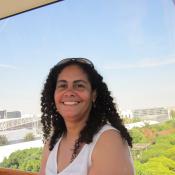 A woman in a white shirt smiles.