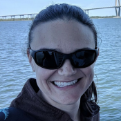 A woman with dark hair smiles.