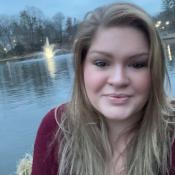 A woman with blond hair looks towards the camera.